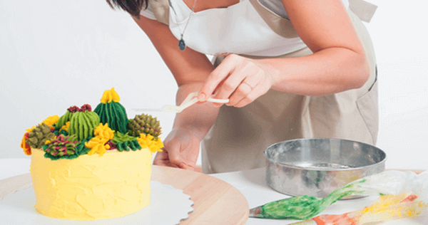 a lady decorating a cake