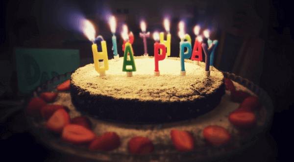 a birthday cake with candles spelling Happy Birthday