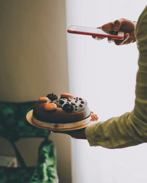 someone is taking a picture of a decorated cake with a cell phone