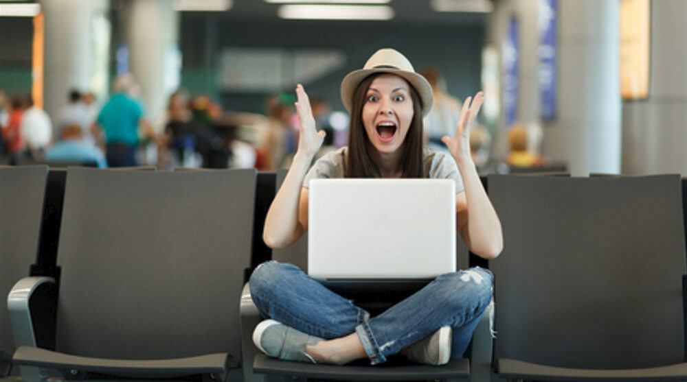 picture of an excited female working on laptop in noisy area