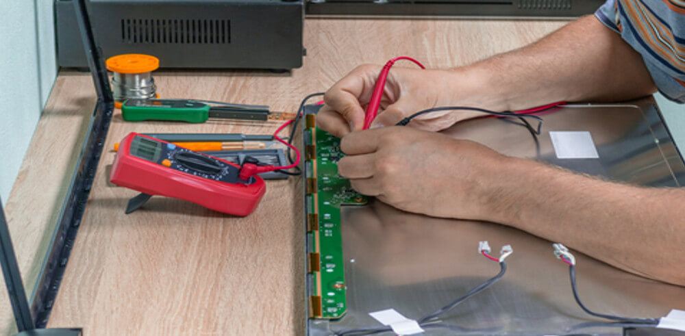 person repairing monitor internally